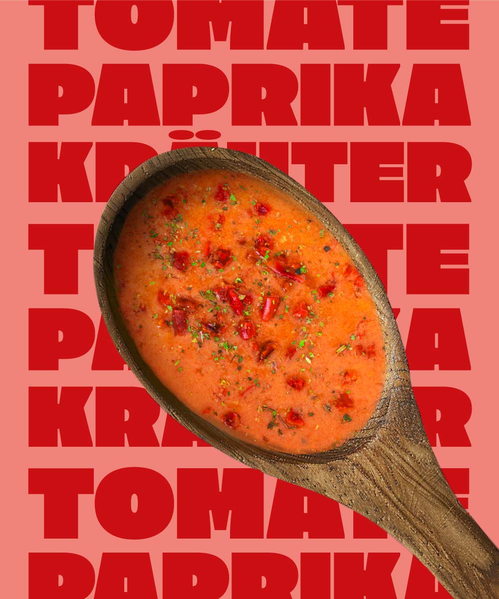 Ein Holzlöffel in dem Miss Mineva's fermentierte Suppe mit Geschmacksrichtung Erbse-Kokos-Minze vor einem bunten Hintergrund zu sehen ist
